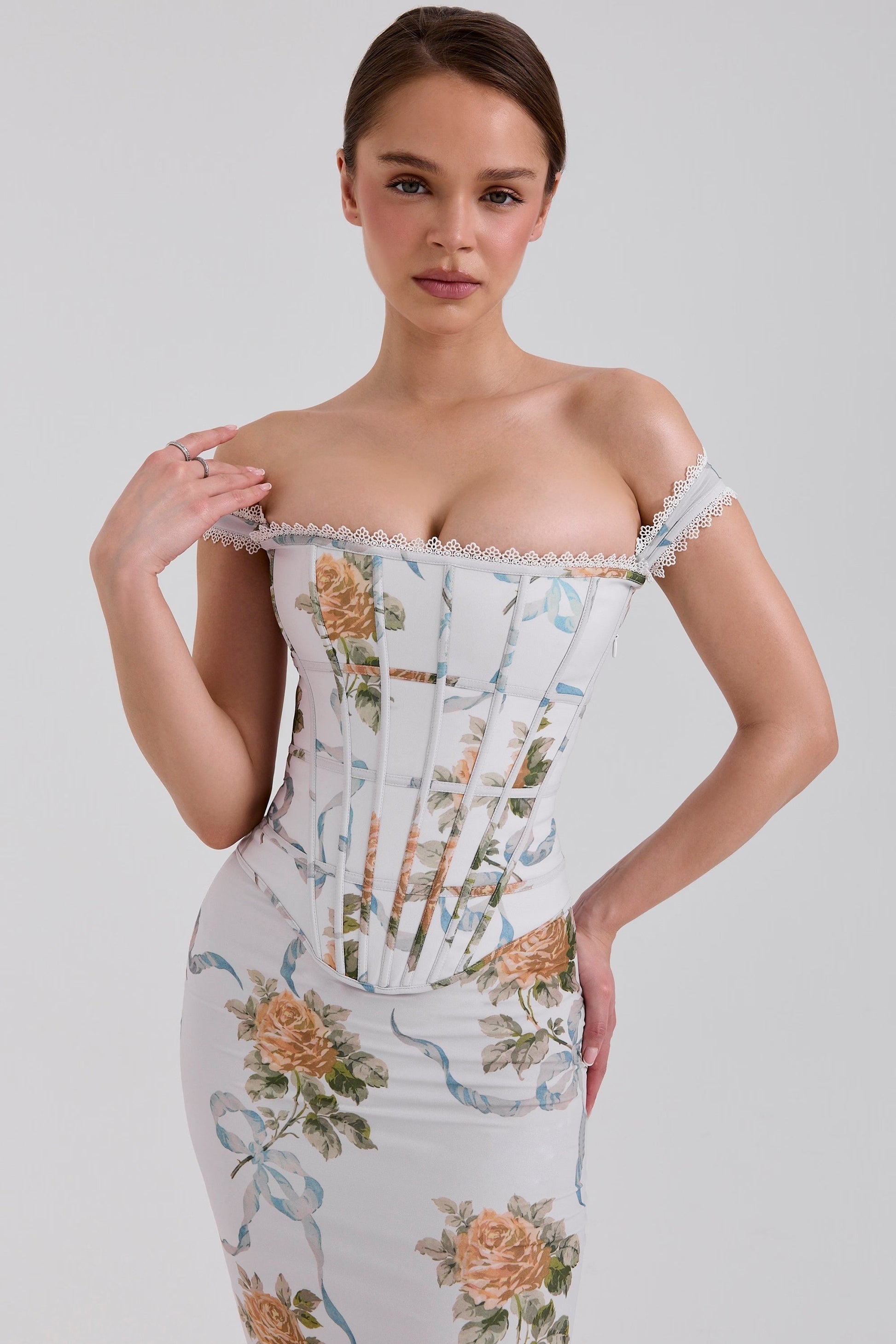 Close-up of the bodice of a white off-shoulder corset floral maxi dress, showcasing the delicate lace trim and rose pattern.