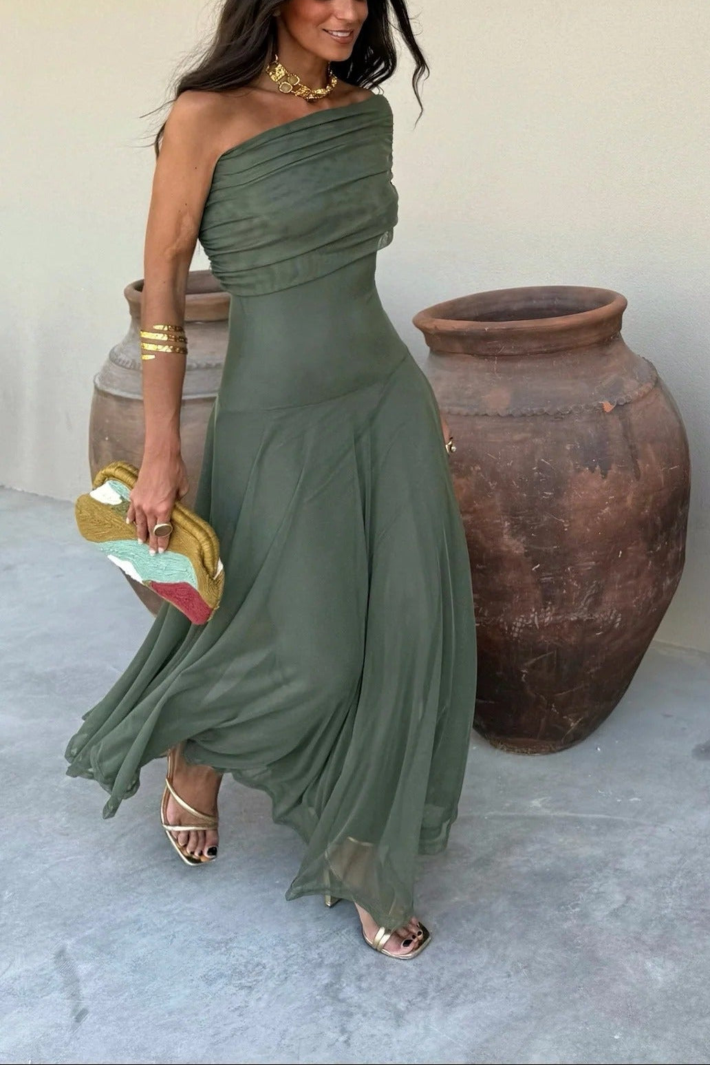 Flowing olive green off-shoulder draped mesh maxi dress with a full skirt, perfect for a special occasion.