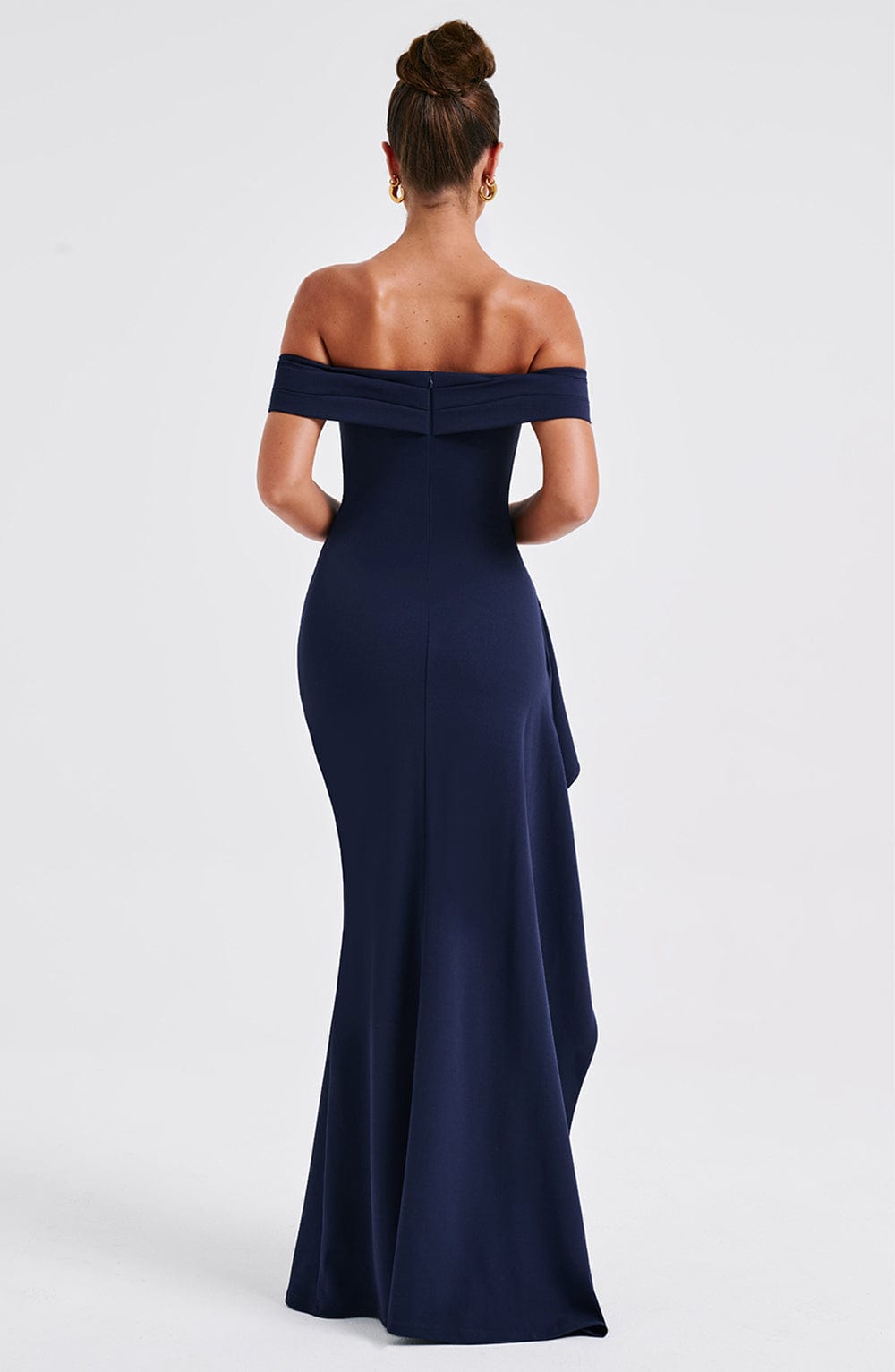 Rear view of the navy blue off-shoulder pleated maxi dress, highlighting the smooth fabric and long train.
