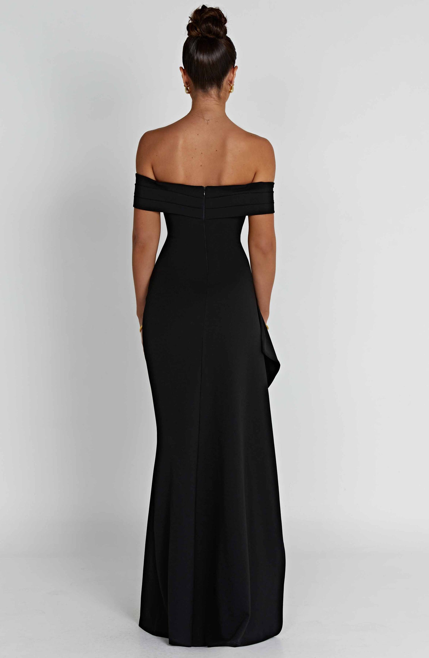 Back view of the black off-shoulder pleated maxi dress, showing the smooth fabric and back zipper detail.