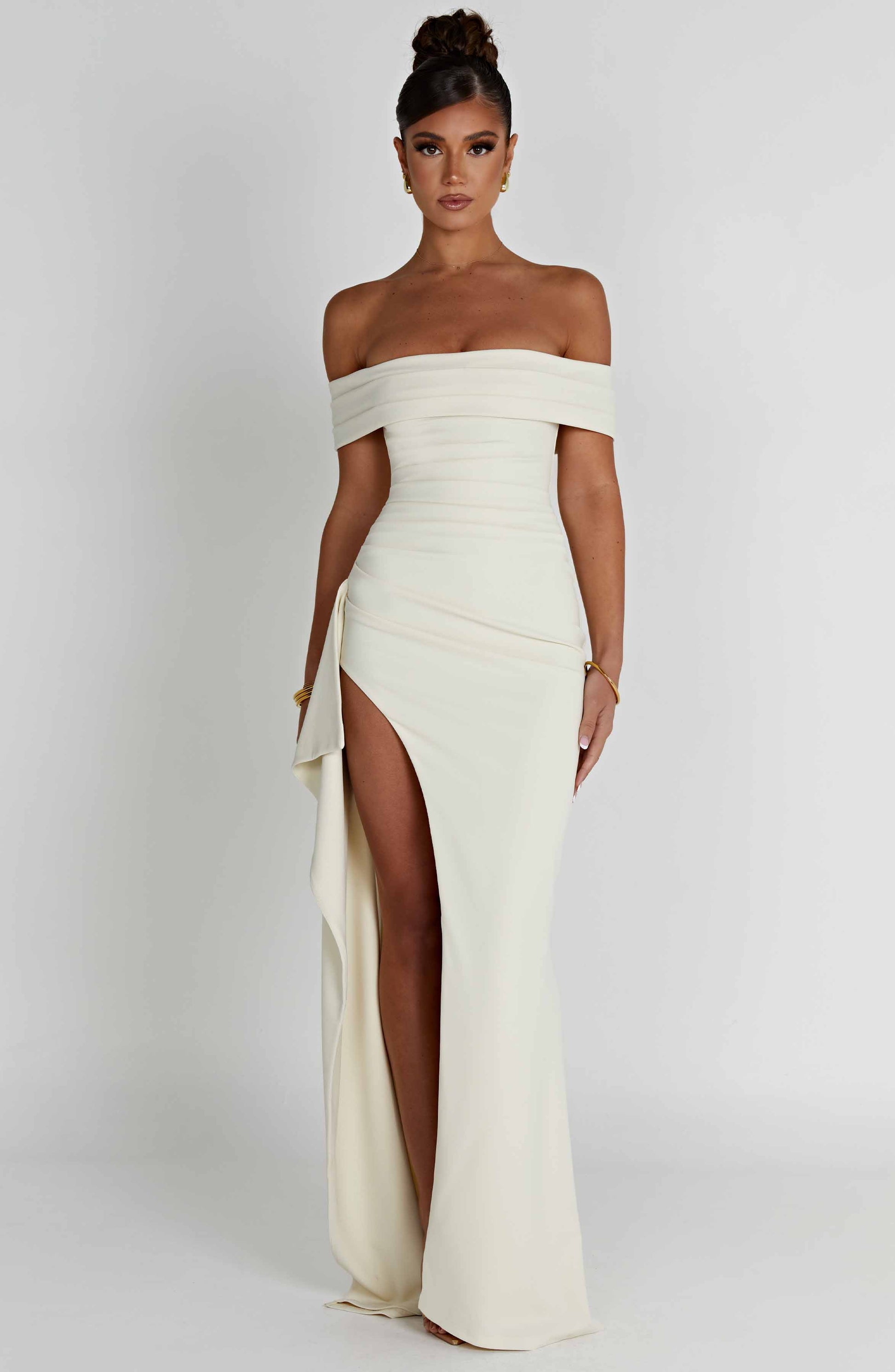 Elegant white off-shoulder pleated maxi dress with a high slit, front view, perfect for a formal occasion.