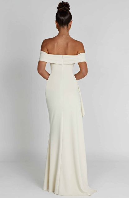 Back view of the white off-shoulder pleated maxi dress, revealing the fitted silhouette and floor-length hem.