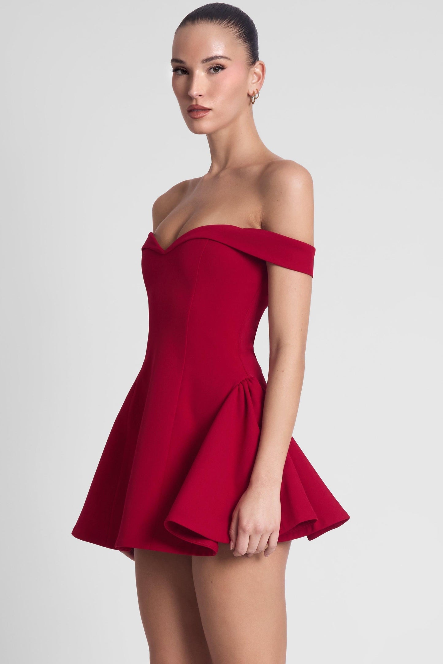 Burgundy red off shoulder sweetheart corset mini dress, side view highlighting flared babydoll skirt