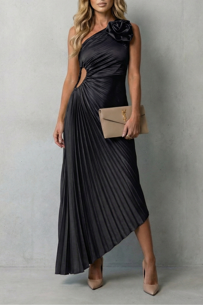 Black one-shoulder pleated maxi dress with a side cut-out, featuring a floral detail on the shoulder, suitable for wedding guest dresses.
