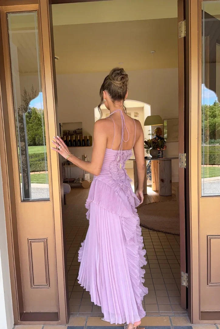 Back view of the lilac one-shoulder ruffle pleated midi dress with delicate halter straps and a flowing skirt.