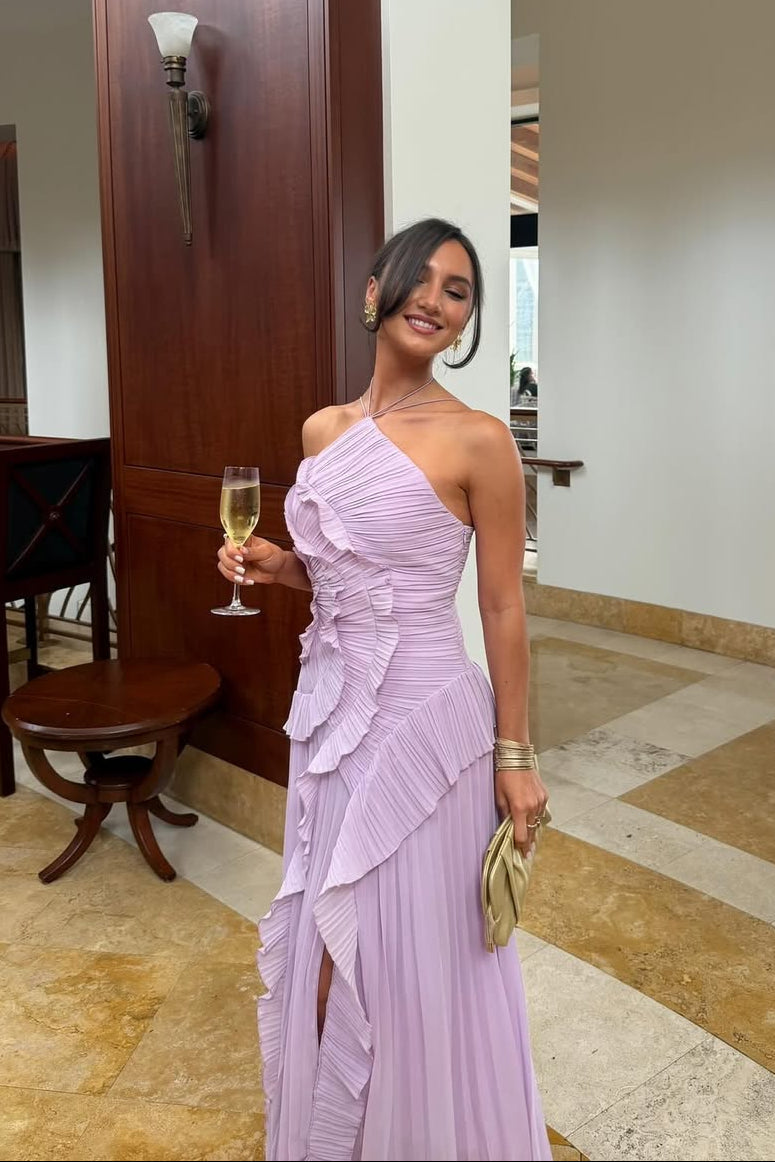 Woman in a radiant pink one-shoulder ruffle pleated midi dress, holding a champagne glass and gold clutch.
