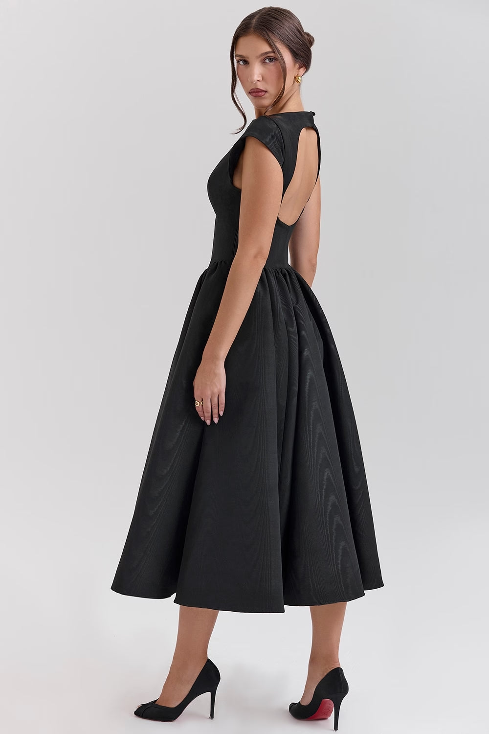 Side profile of a black open back square neck midi dress, highlighting the flared skirt and cap sleeves.