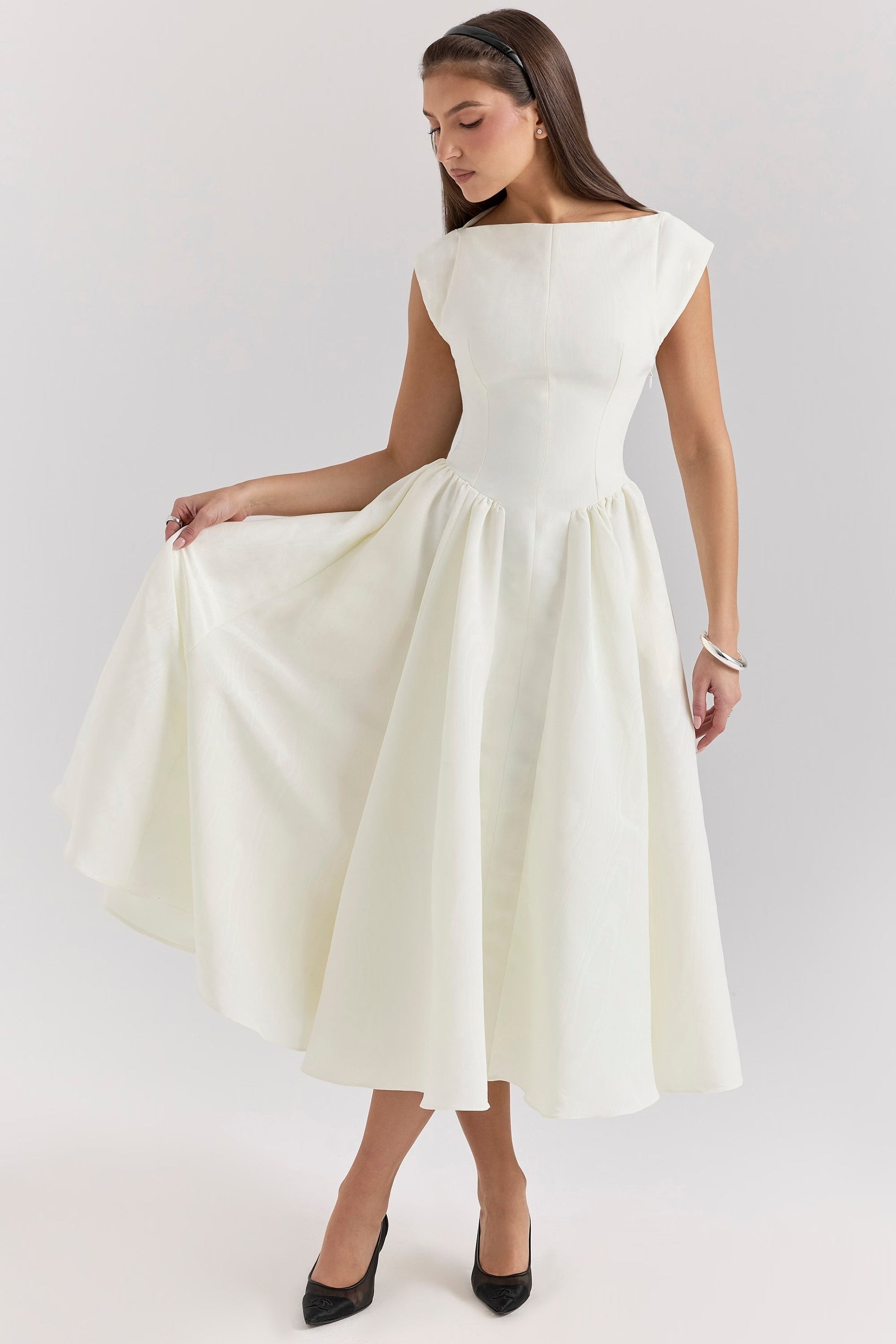 Front view of a white square neck midi dress with cap sleeves, showing the texture of the fabric and full skirt.
