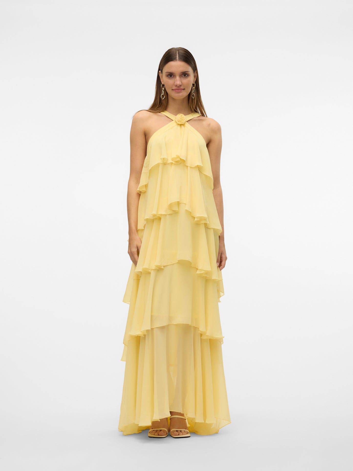 Front flat lay of a yellow halter ruffle backless maxi dress, highlighting the tiered ruffles, halter neckline with a rose accent, and long flowing skirt. A beautiful vacation dress.