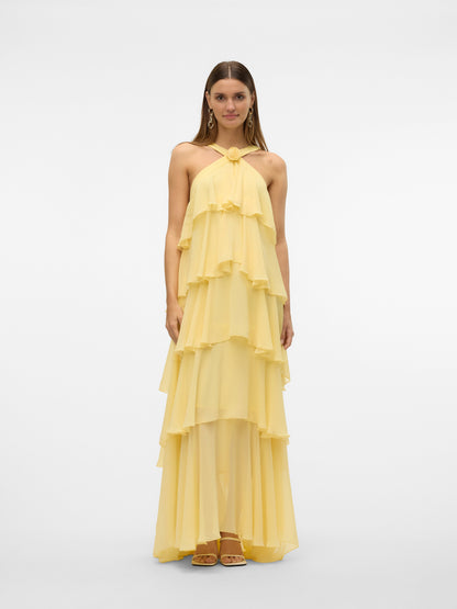 Front flat lay of a yellow halter ruffle backless maxi dress, highlighting the tiered ruffles, halter neckline with a rose accent, and long flowing skirt. A beautiful vacation dress.
