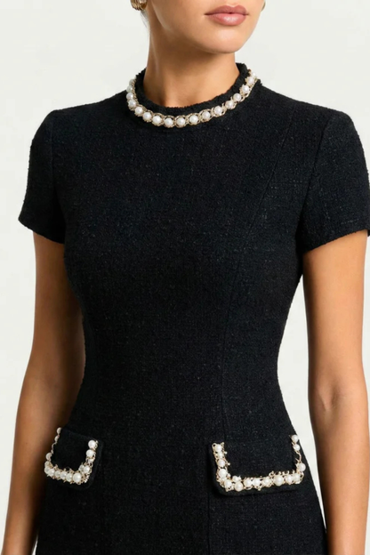 Close-up of black pearl trim mock neck mini dress, showing pearl details on collar and pockets.