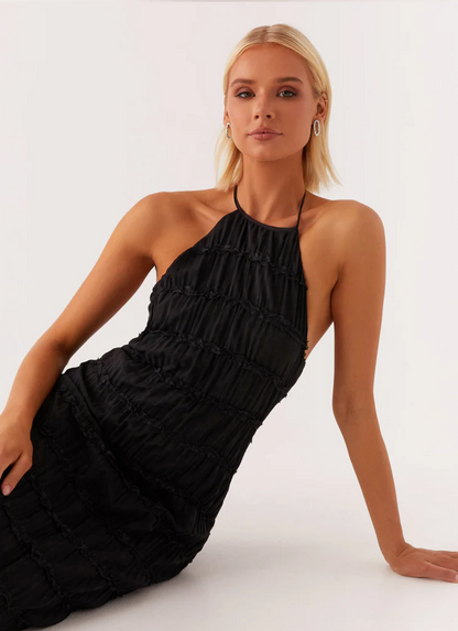Black halter neck maxi dress close-up showing ruched tiered texture and fitted bodycon silhouette