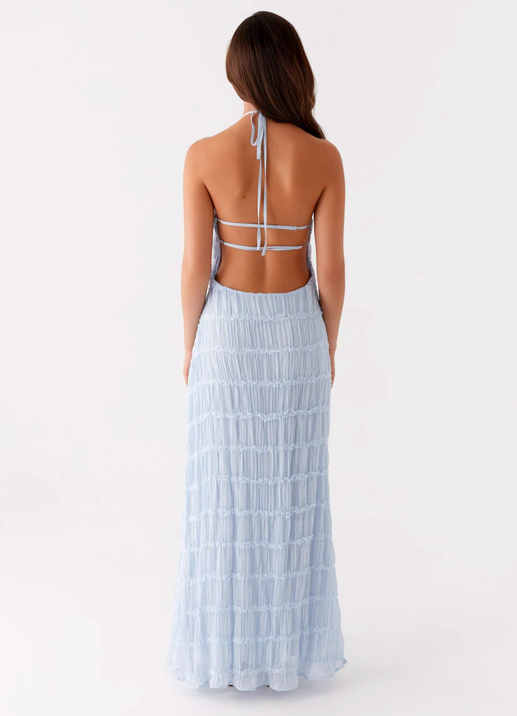 Light blue halter maxi dress back view with tie neck, open back straps, and pleated tiered skirt