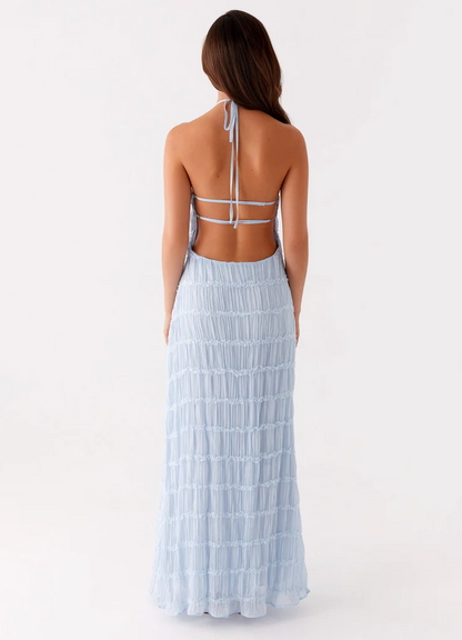 Light blue halter maxi dress back view with tie neck, open back straps, and pleated tiered skirt