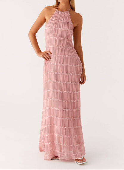 Angled view of blush pink halter maxi dress highlighting fitted waist and lace tiers