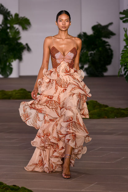 Full-length view of the women's printed beaded butterfly maxi dress with tiered ruffles, worn on a runway.