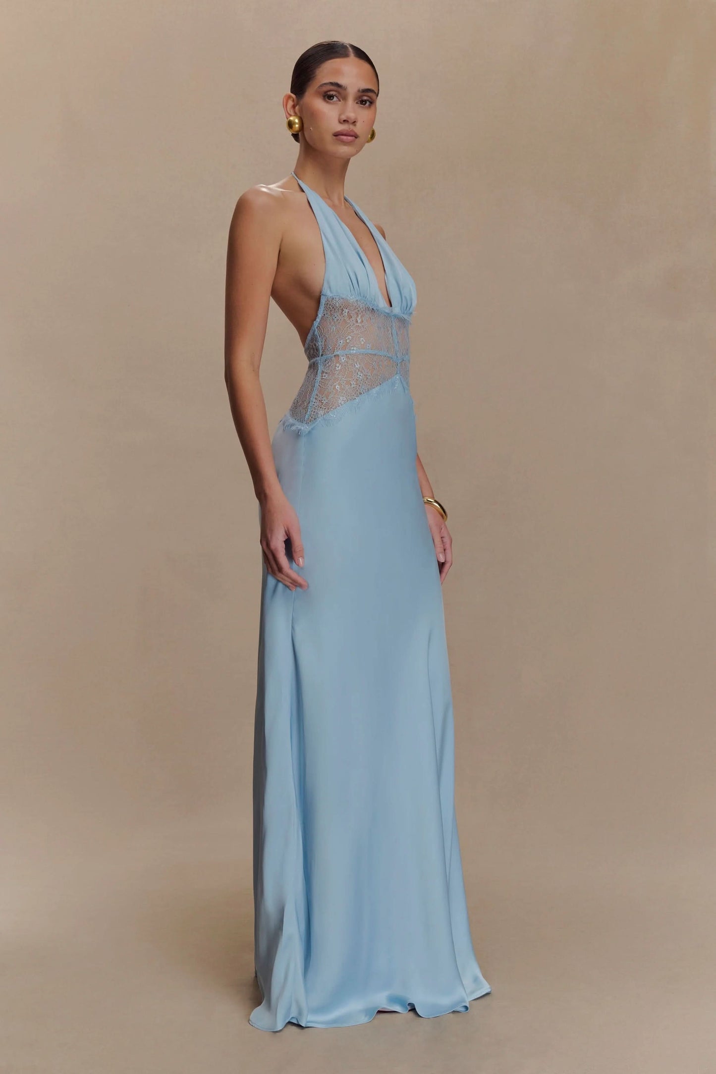 Side view of a women's light blue halter V-neck maxi dress, showcasing the elegant drape and lace detailing, perfect for a midi dress with sleeves alternative.
