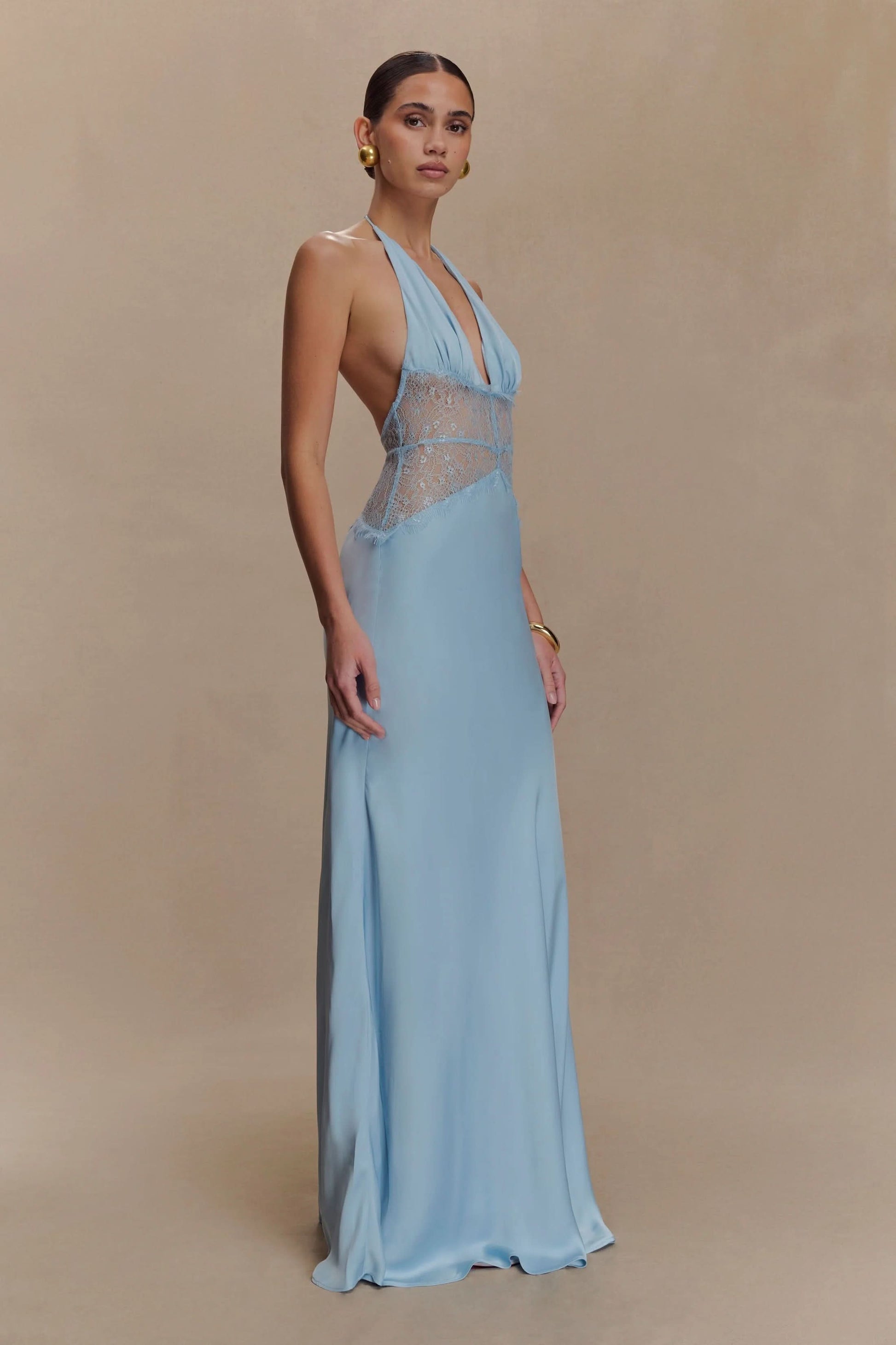 Side view of a women's light blue halter V-neck maxi dress, showcasing the elegant drape and lace detailing, perfect for a midi dress with sleeves alternative.