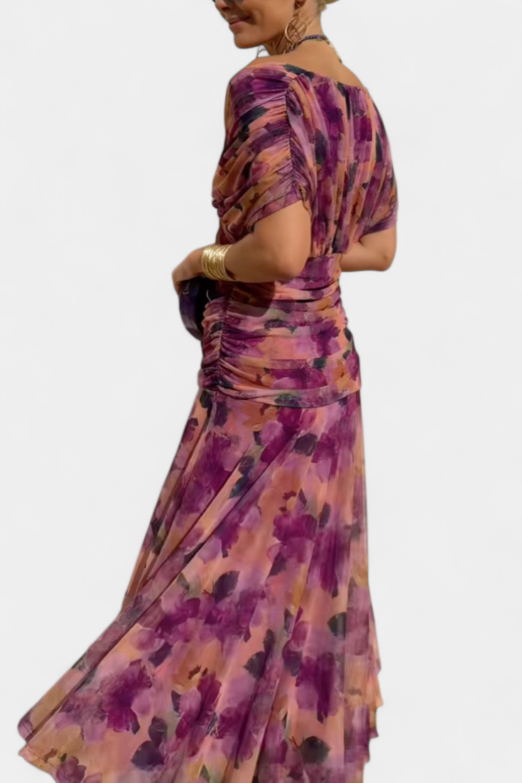 Side view of purple printed off shoulder ruched maxi dress with gathered sleeves and flowy skirt