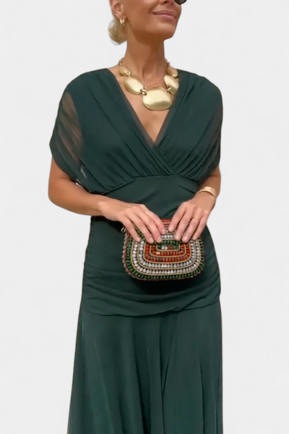 Deep green draped ruched maxi dress front view with gathered bodice and soft flowing skirt panels