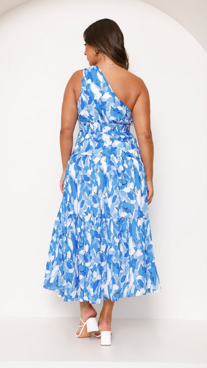 Back view of a plus size women's blue and white printed one-shoulder midi dress with a flowing tiered skirt.