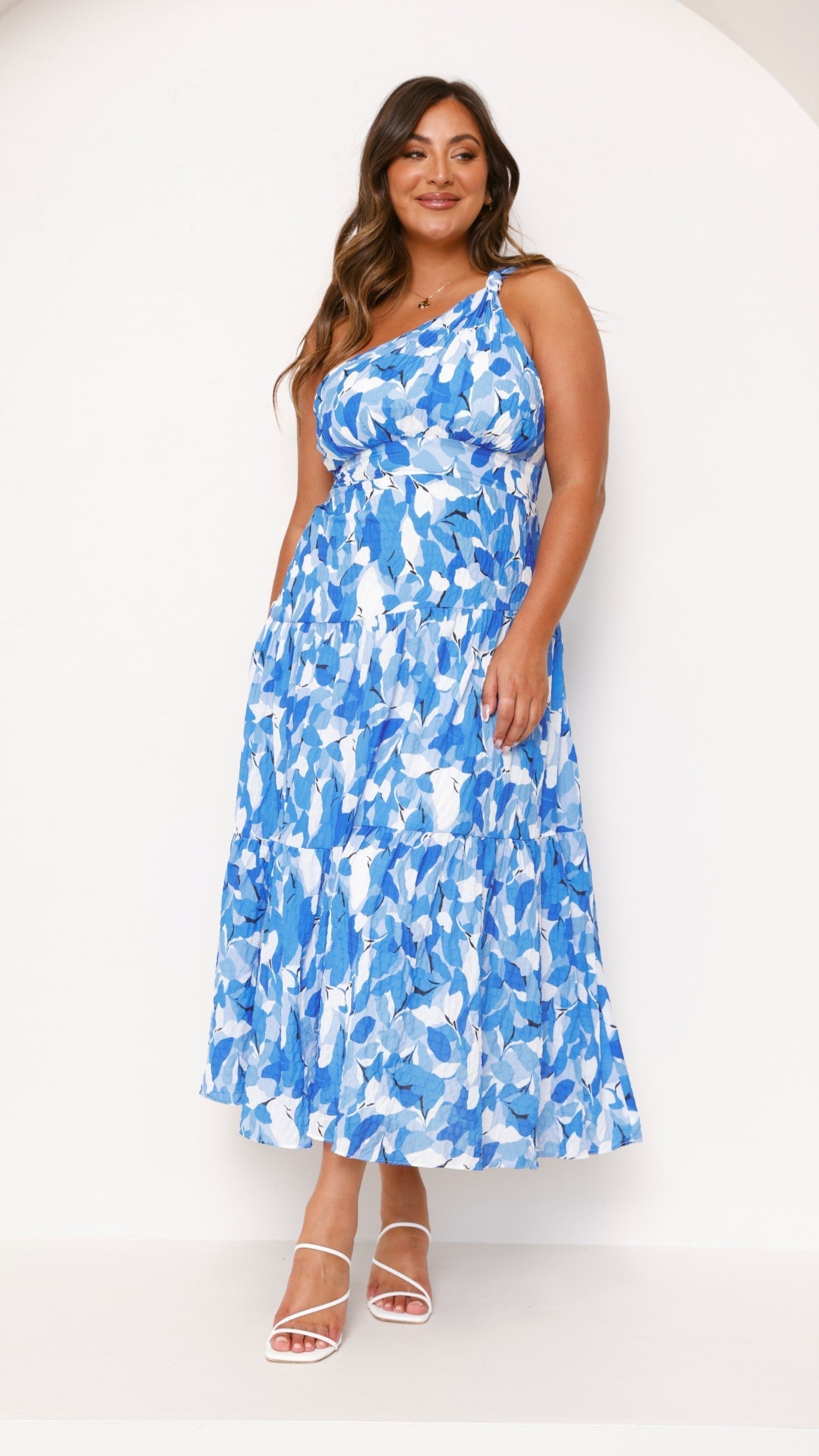 Front view of a plus size women's blue and white printed one-shoulder midi dress, showcasing the full silhouette.
