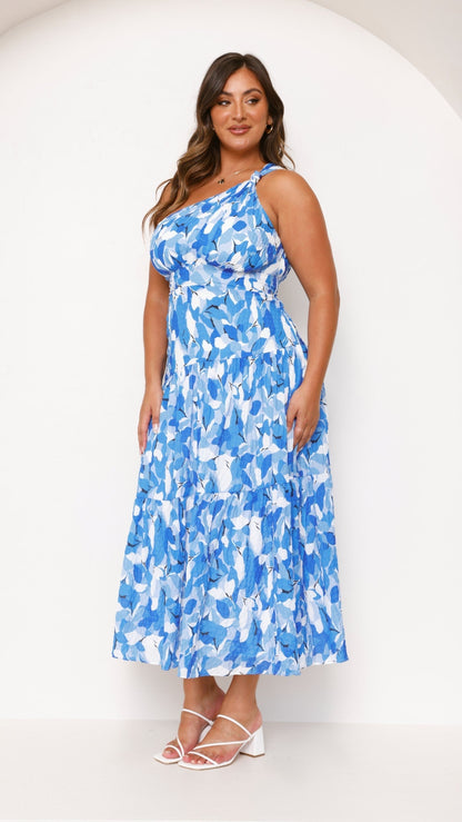 Side profile of a plus size women's blue and white printed one-shoulder midi dress, highlighting the tiered design.