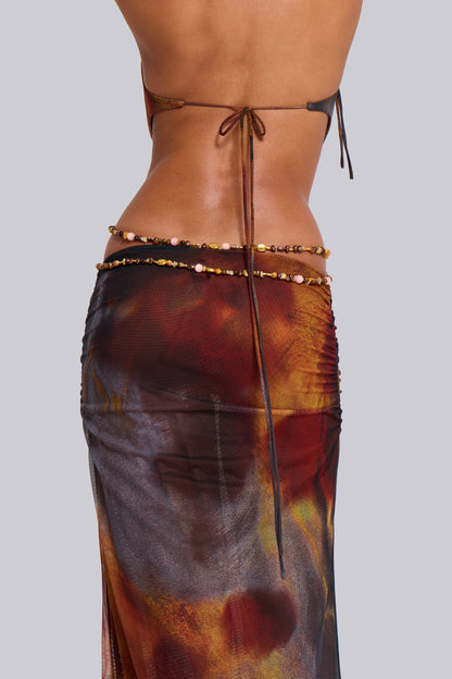 Back close-up of the waist and lower back of the printed halter maxi dress, showing the tie closure and beaded waist chain.