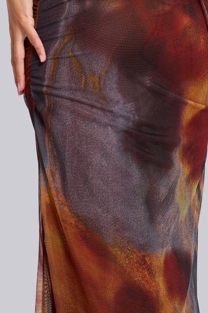 Texture and print detail of the lower skirt of the women's printed maxi dress, featuring a mix of brown, orange, and black patterns.