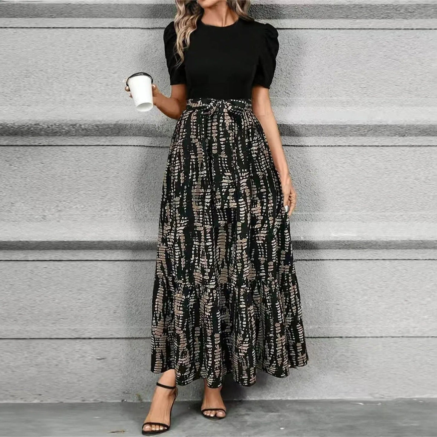 Women's printed puff sleeve maxi dress featuring a black top and abstract brown and black patterned skirt, ideal for vacation.