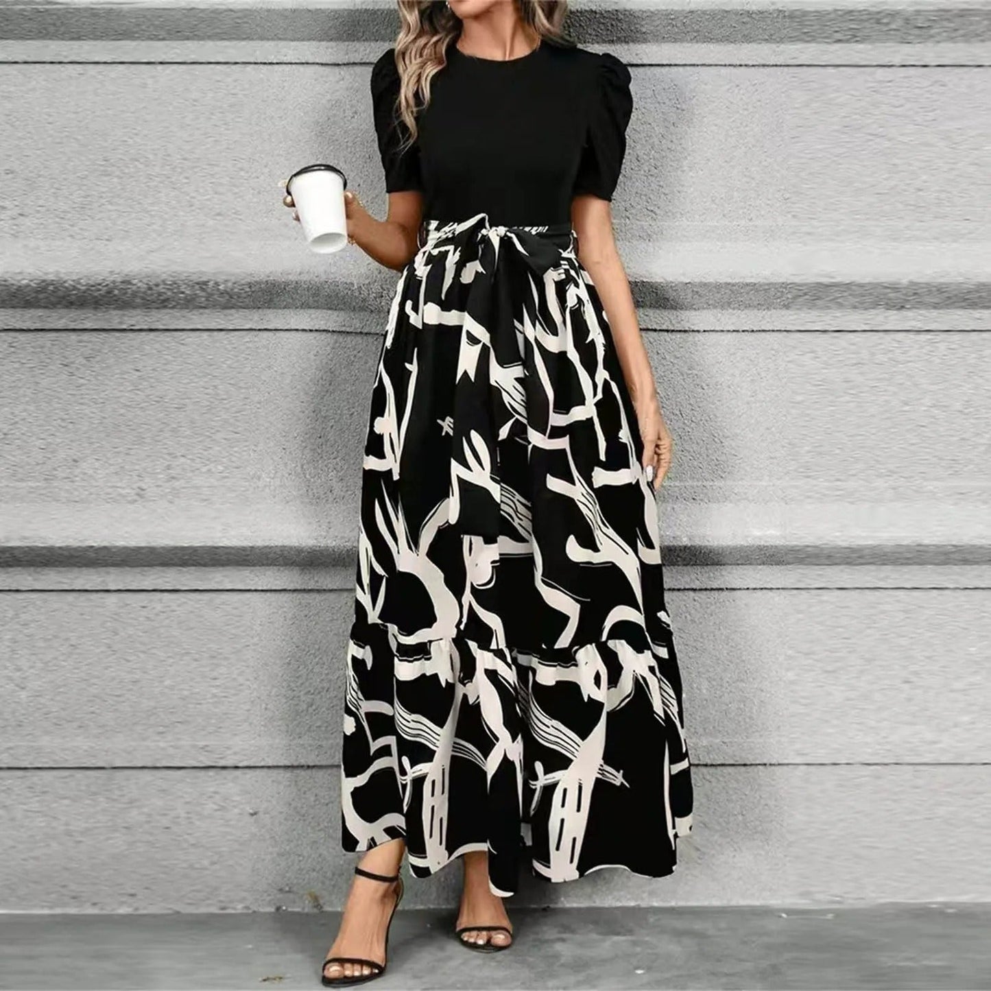 Women's black and white abstract print maxi dress with puff sleeves and a flattering tie waist, a stylish midi dress.