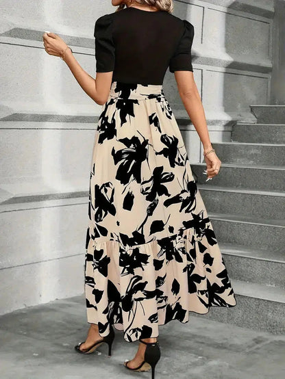 Back view of women's black and beige floral printed maxi dress with puff sleeves, showcasing the flowing skirt.