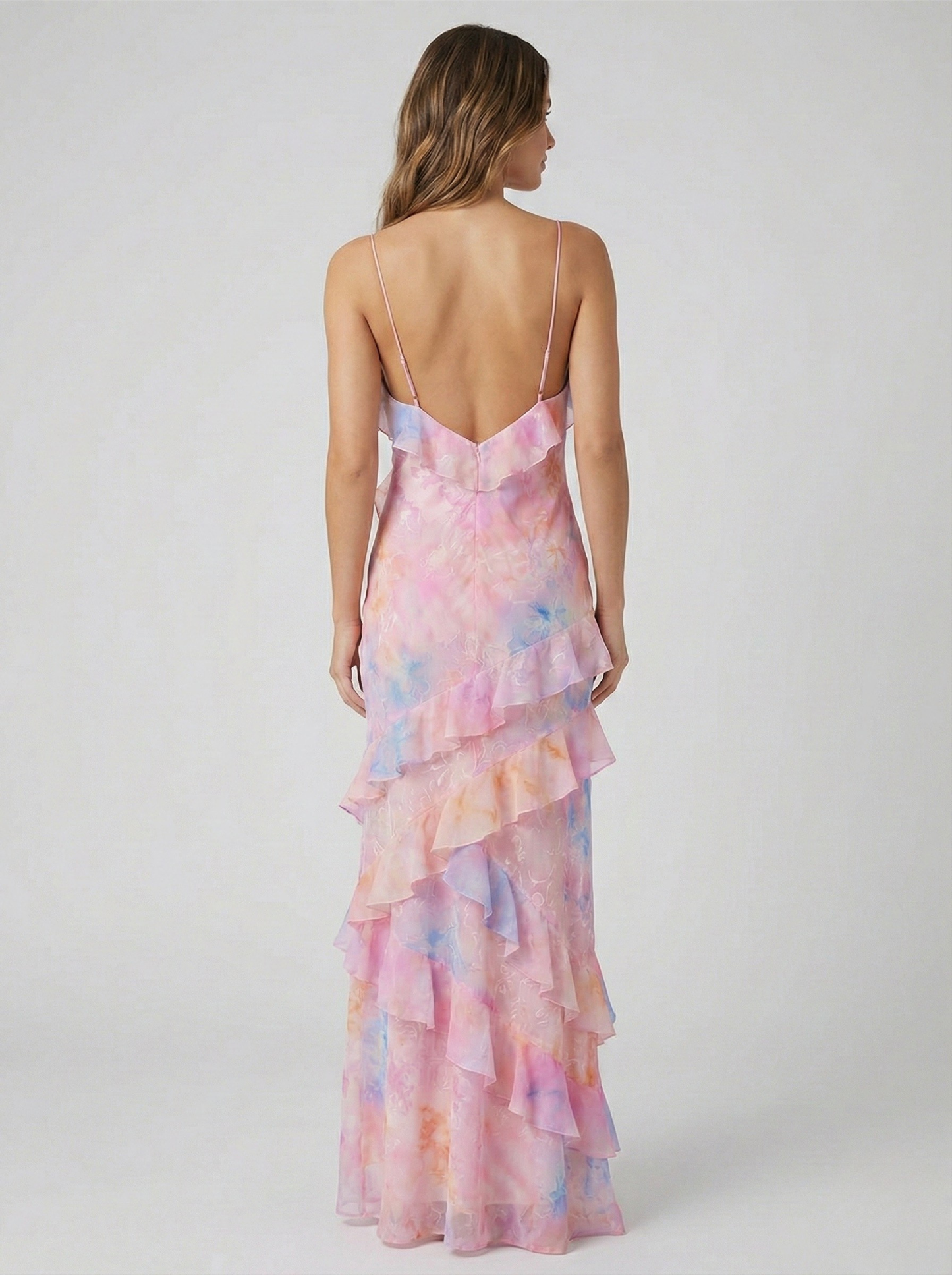 Back view of women's pink and blue ruffled maxi dress showing open back design and spaghetti straps.