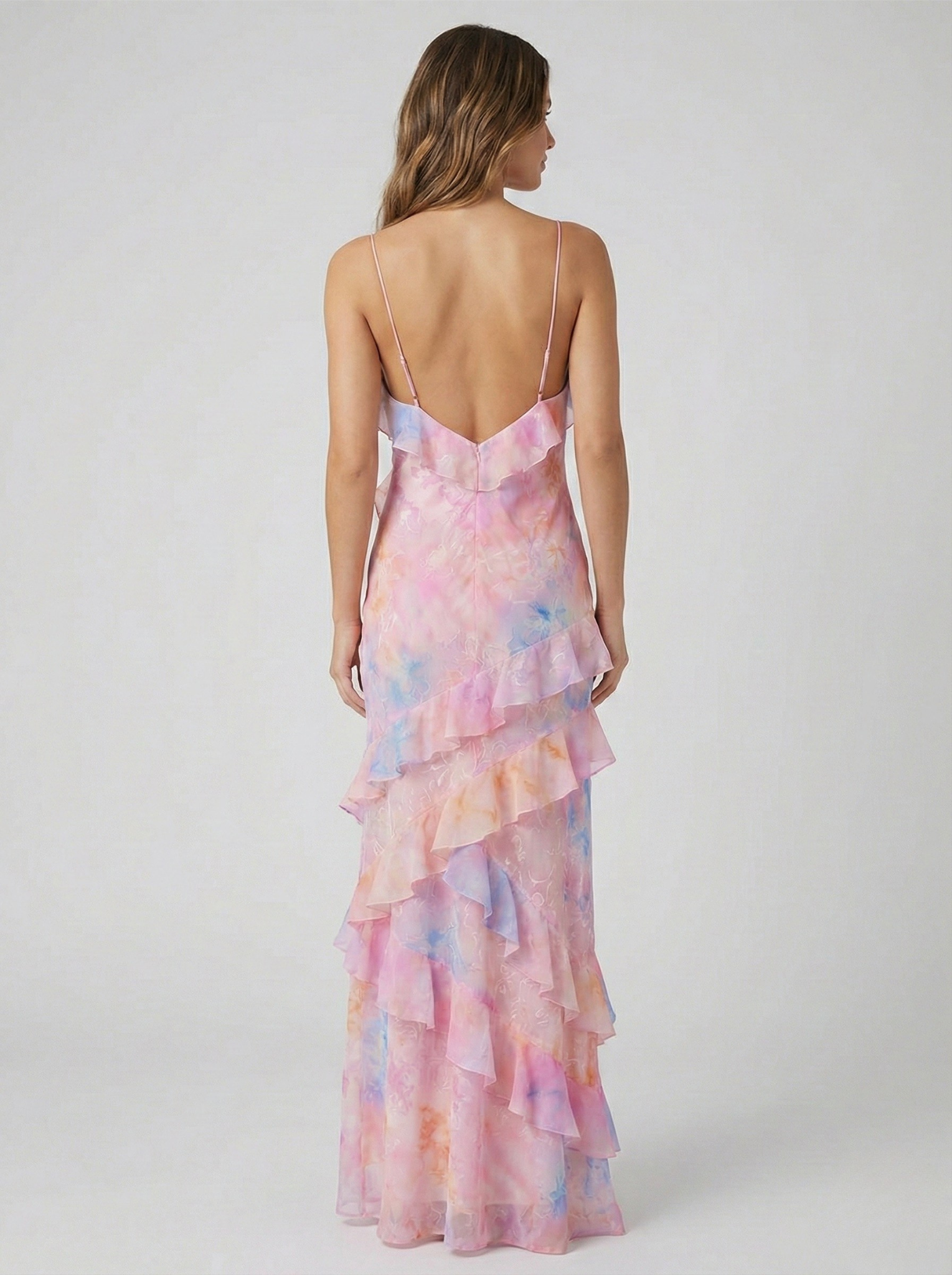 Back view of women's pink and blue ruffled maxi dress showing open back design and spaghetti straps.