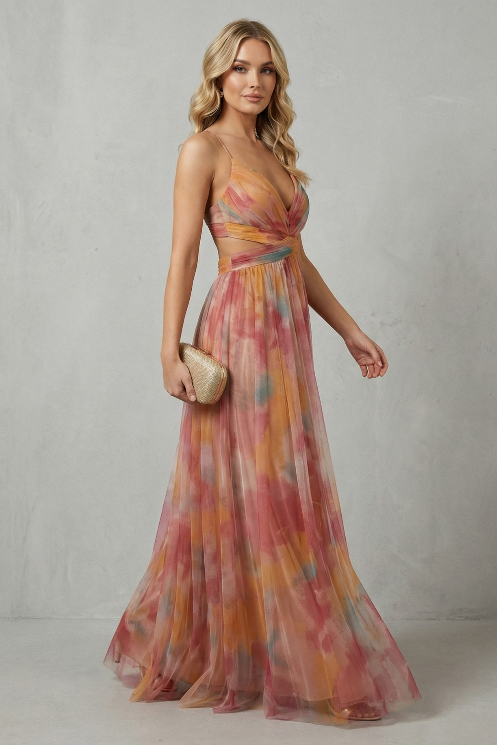 Side view of a women's formal maxi dress with V-neck, cut-outs, and a colorful orange, pink, and yellow print, showcasing its flowing silhouette.
