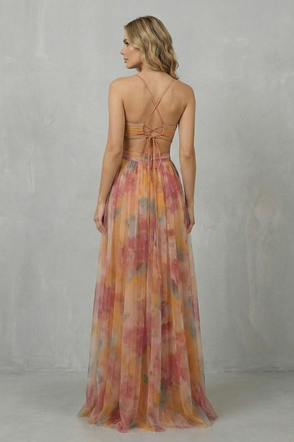Back view of the women's formal maxi dress, showing the criss-cross spaghetti straps and open back design of the orange, pink, and yellow print.