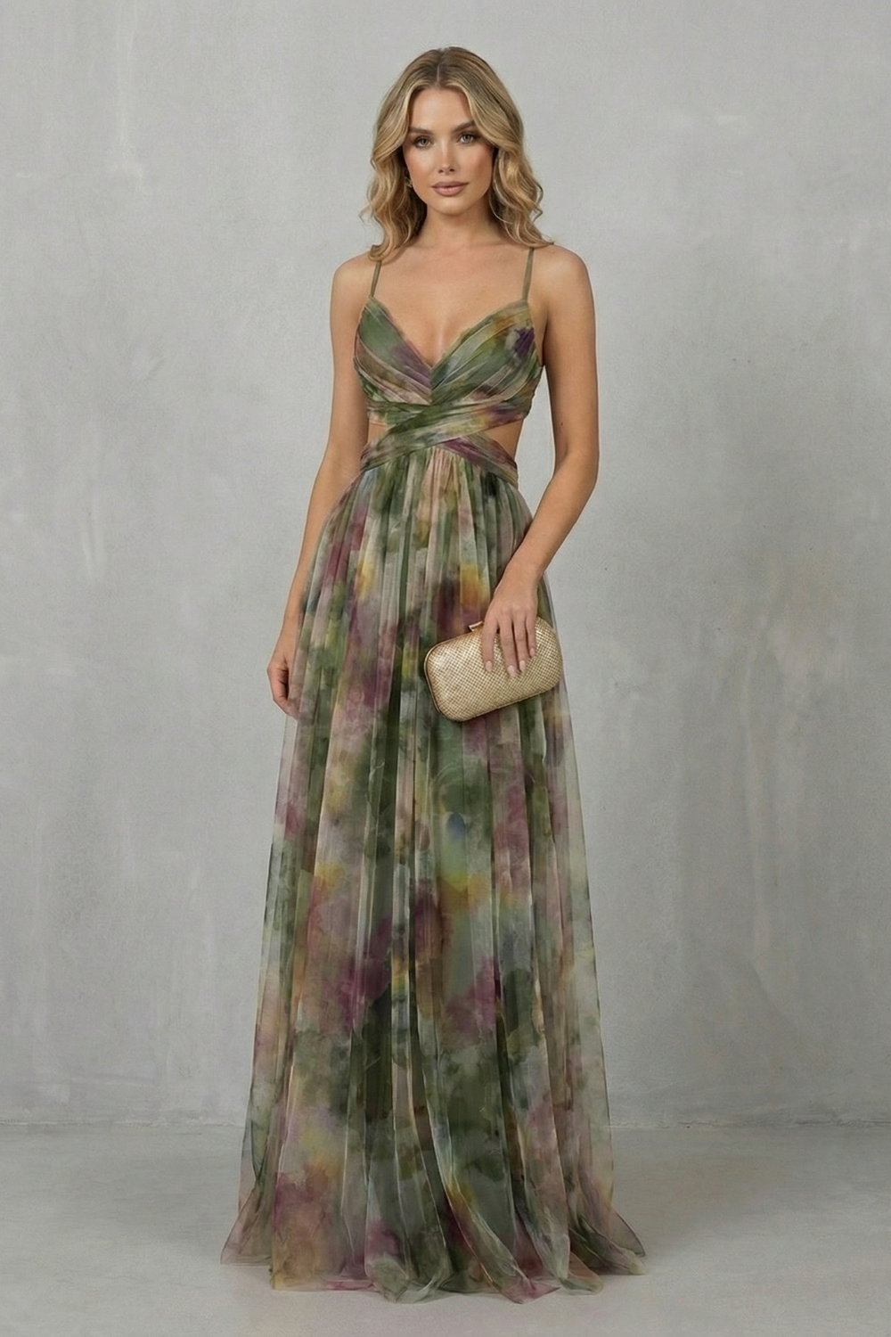 Elegant women's printed V-neck formal maxi dress in a flowing green, purple, and yellow pattern, with subtle waist cut-outs and spaghetti straps.