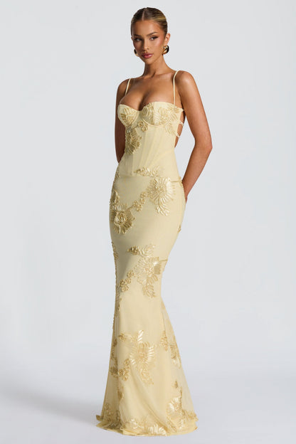 Back view of the light yellow floral sweetheart maxi dress, featuring a lace-up back detail and embroidered floral pattern.