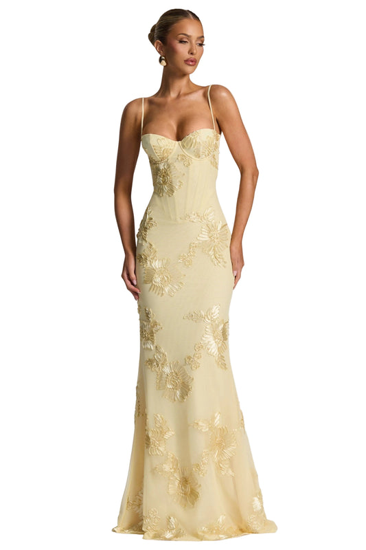 Full-length view of a light yellow floral sweetheart maxi dress with spaghetti straps and intricate embroidered flowers.
