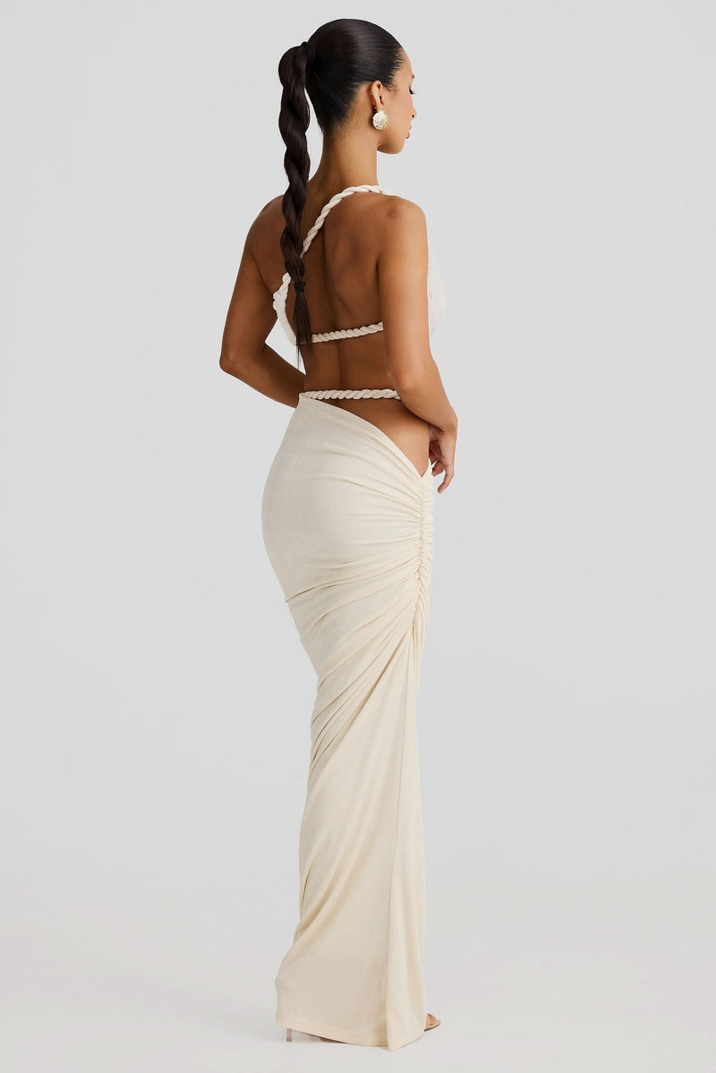 Back view of a women's cream ruched cut out maxi 2 piece set, showing braided rope straps and ruched skirt.