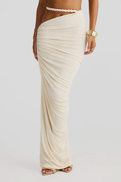 Close up of the cream ruched maxi skirt with a cut out detail and braided rope waist tie.