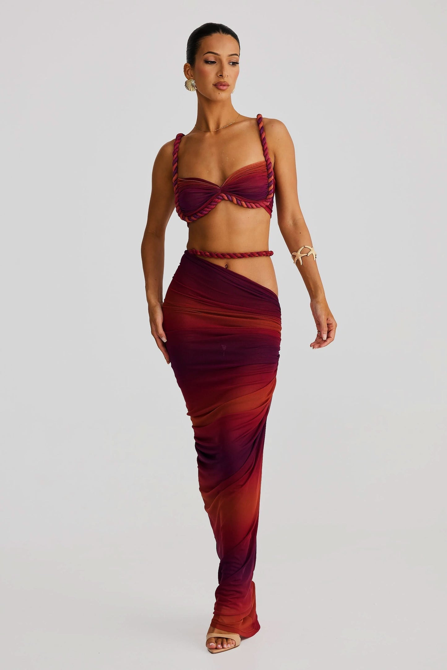 Front view of a women's ombre red and burgundy ruched cut out strapless maxi 2 piece set.