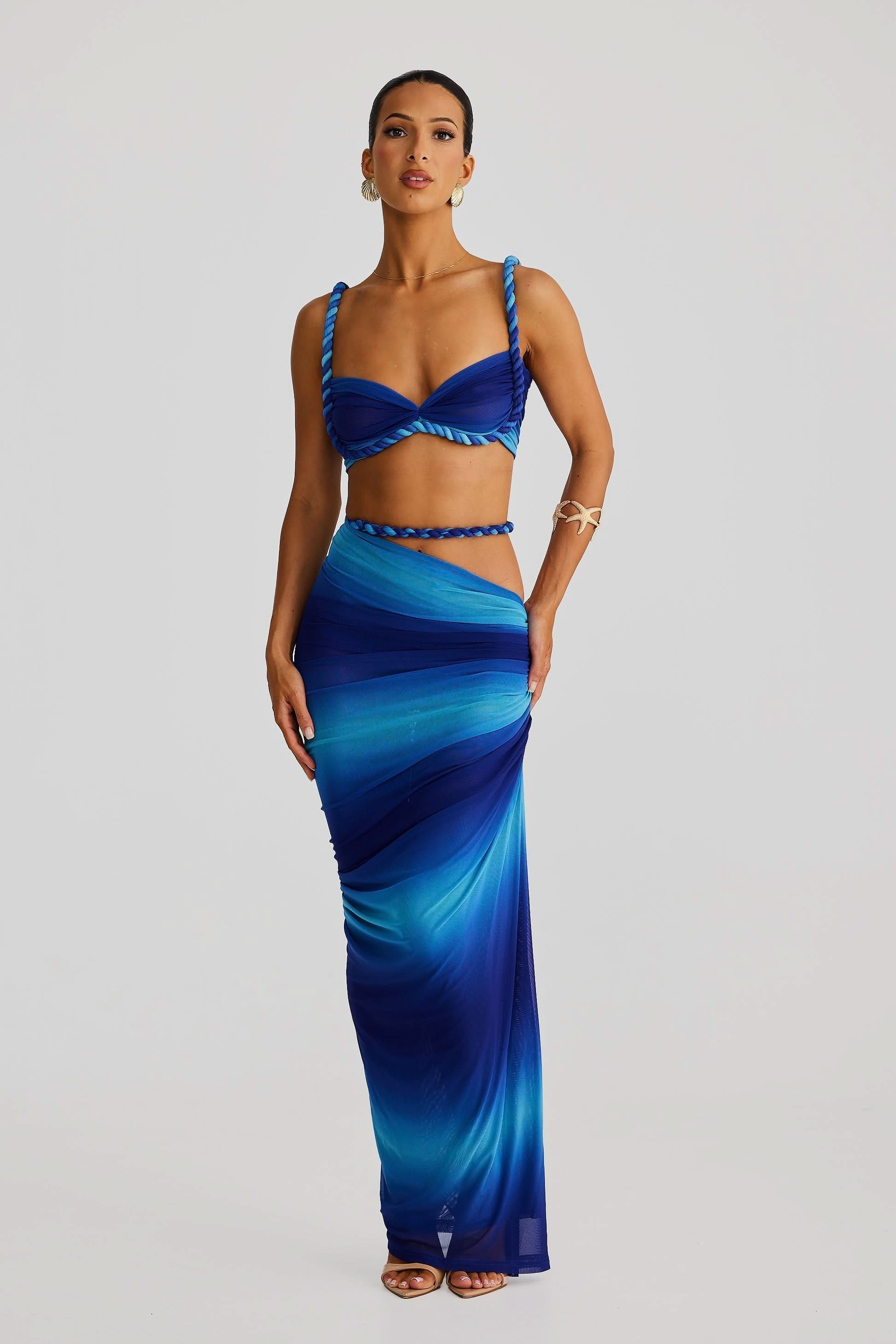 Front view of a women's ombre blue ruched cut out strapless maxi 2 piece set with braided rope details.
