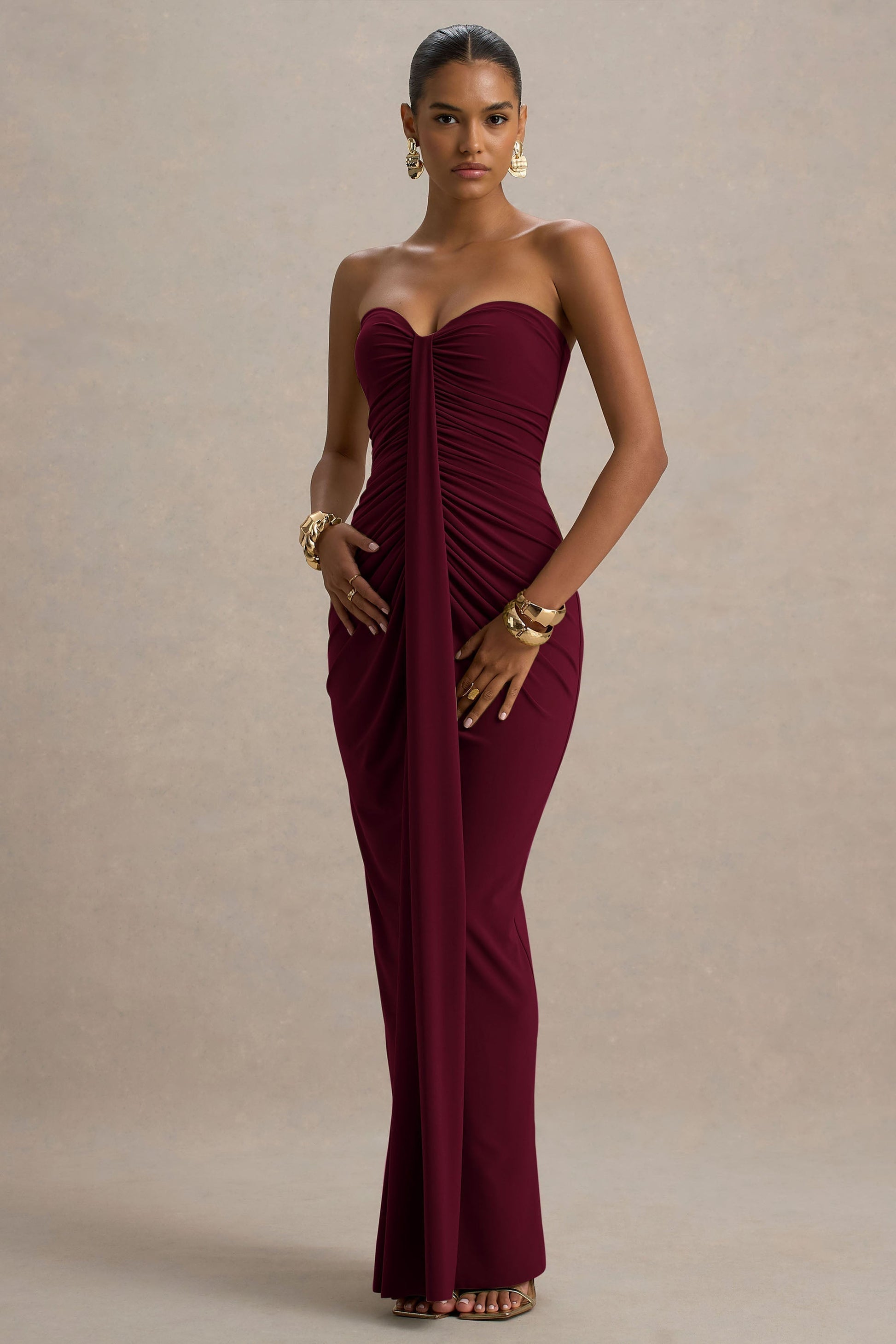 Full-length burgundy off shoulder ruched slinky jersey maxi dress with center drape and fitted bodycon skirt