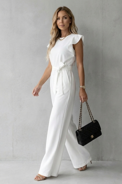 Side profile of a white ruffle sleeve wide leg jumpsuit with a cinched waist belt, showcasing flowy pants.