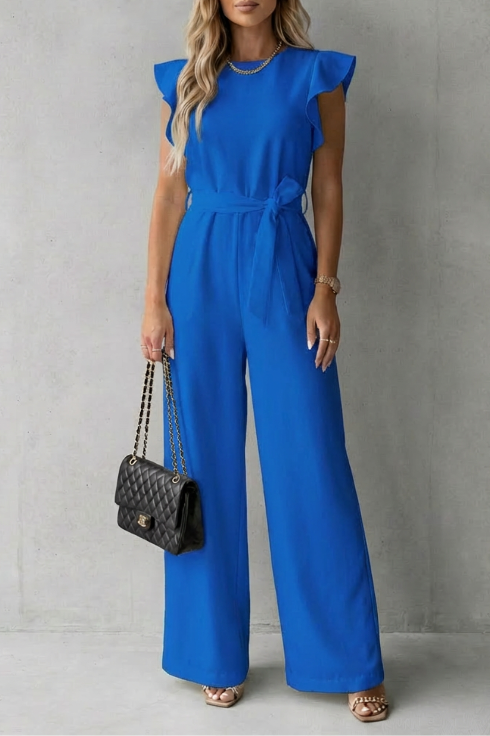 Vibrant blue ruffle sleeve wide leg jumpsuit with a self-tie belt, a stylish ladies denim jumpsuit alternative.