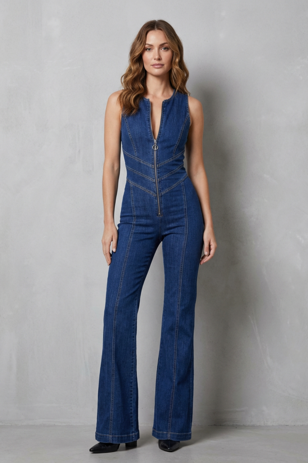Front view of women's denim jumpsuit featuring a full-length zipper and flared jeans silhouette