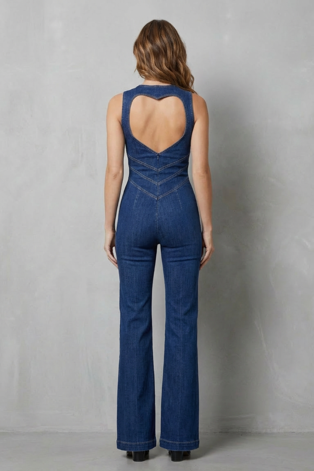 Back view of women's denim jumpsuit for women with unique heart-shaped cutout and bell bottom jeans