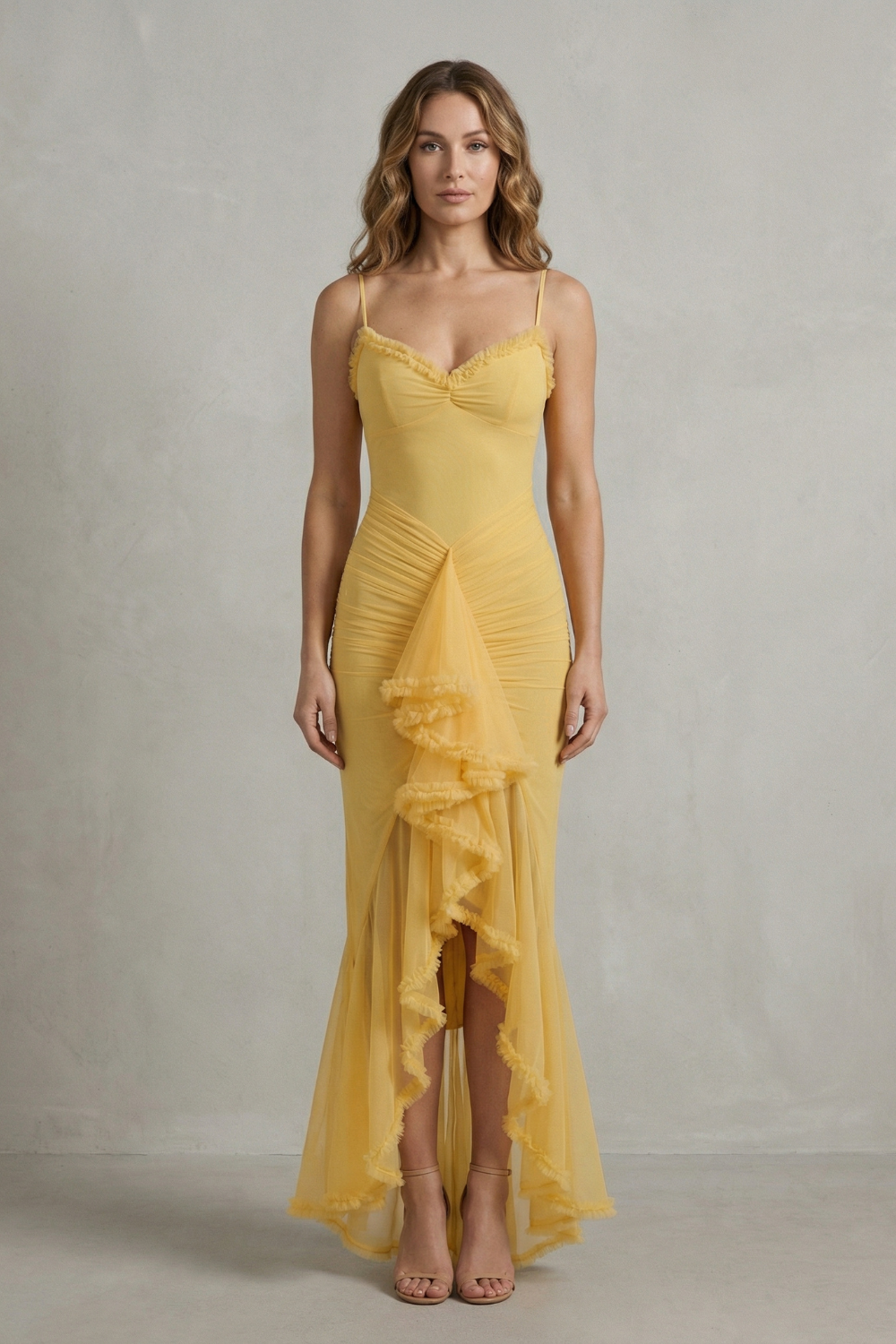 Full-length front view of a woman wearing a yellow sleeveless ruched ruffle maxi dress, showcasing the elegant design and flowing skirt.