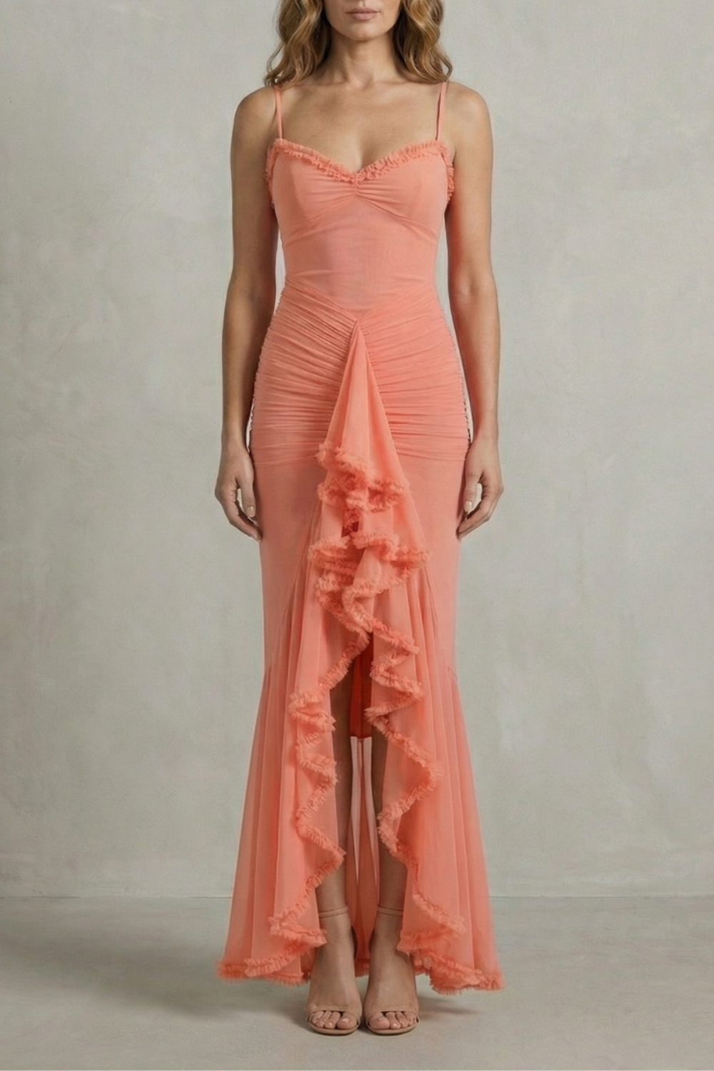 Front view of a coral sleeveless ruched ruffle maxi dress with delicate spaghetti straps, an elegant dress for wedding guests.